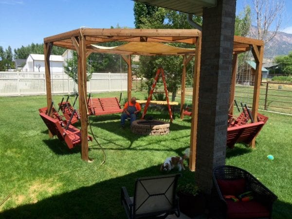 DIY round pergola with swings, firepit and shade screen featured on @Remodelaholic